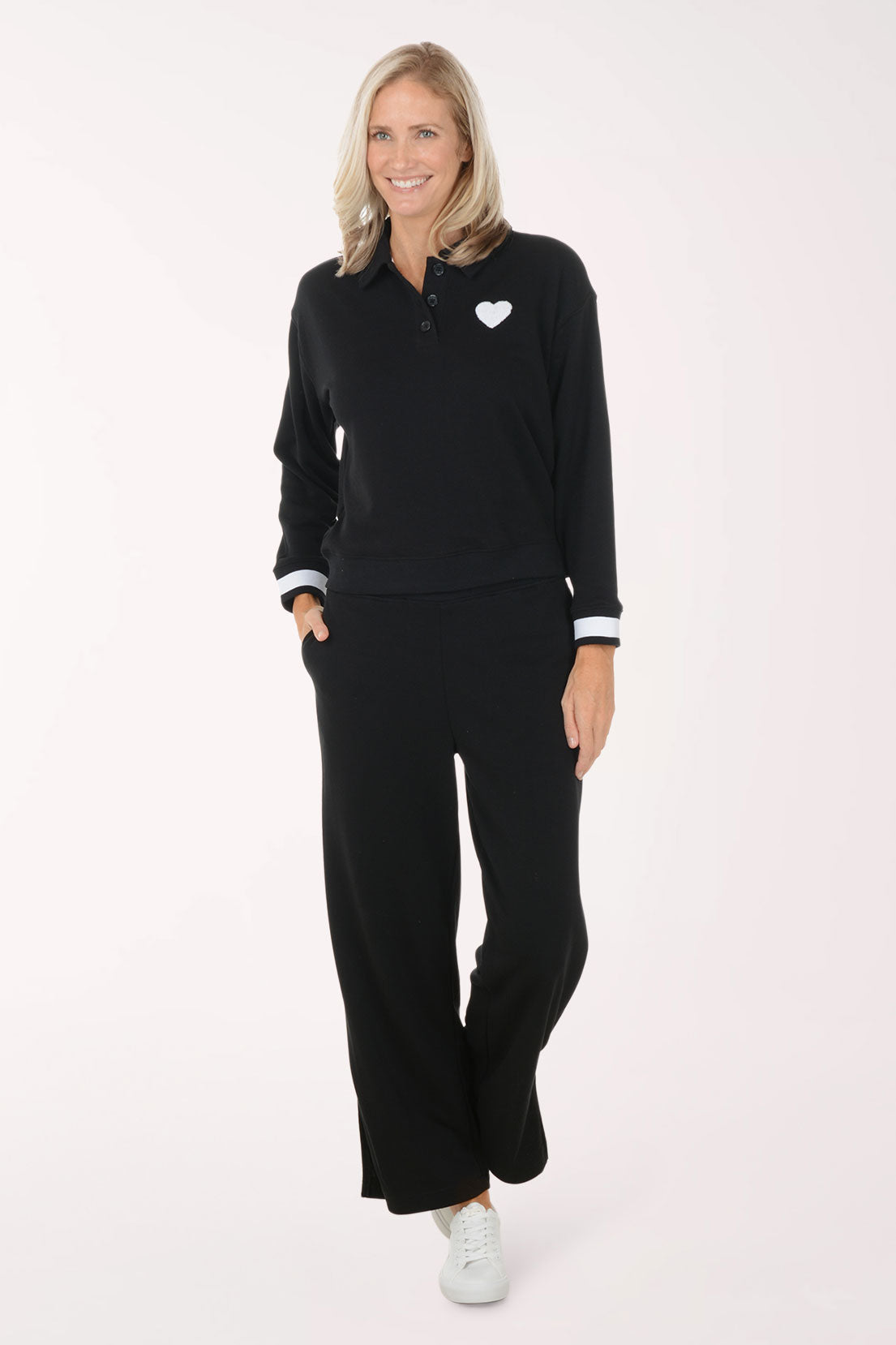 Woman wearing a black outfit with a heart emblem on a white background