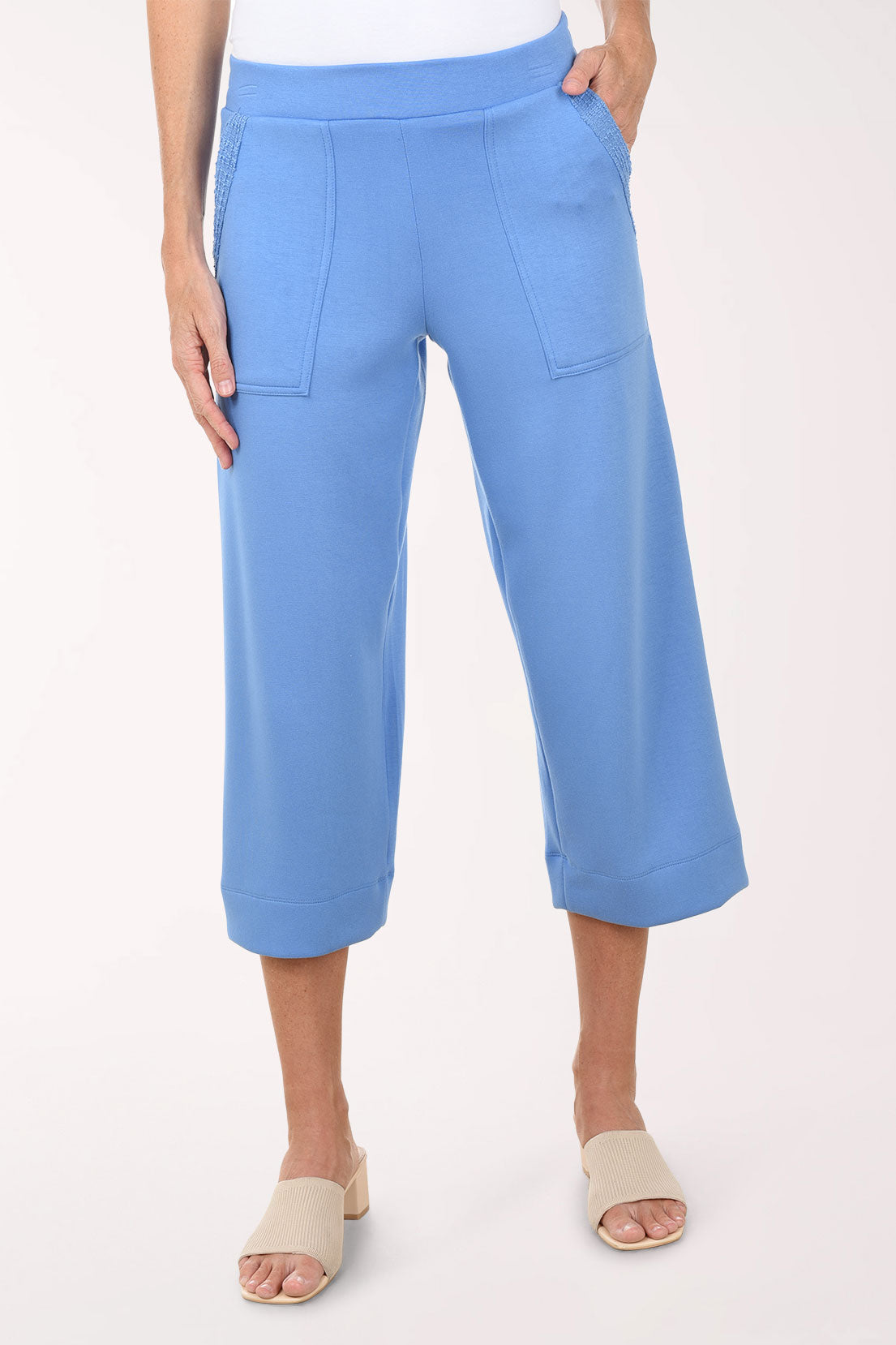 Person wearing light blue capri pants on a white background