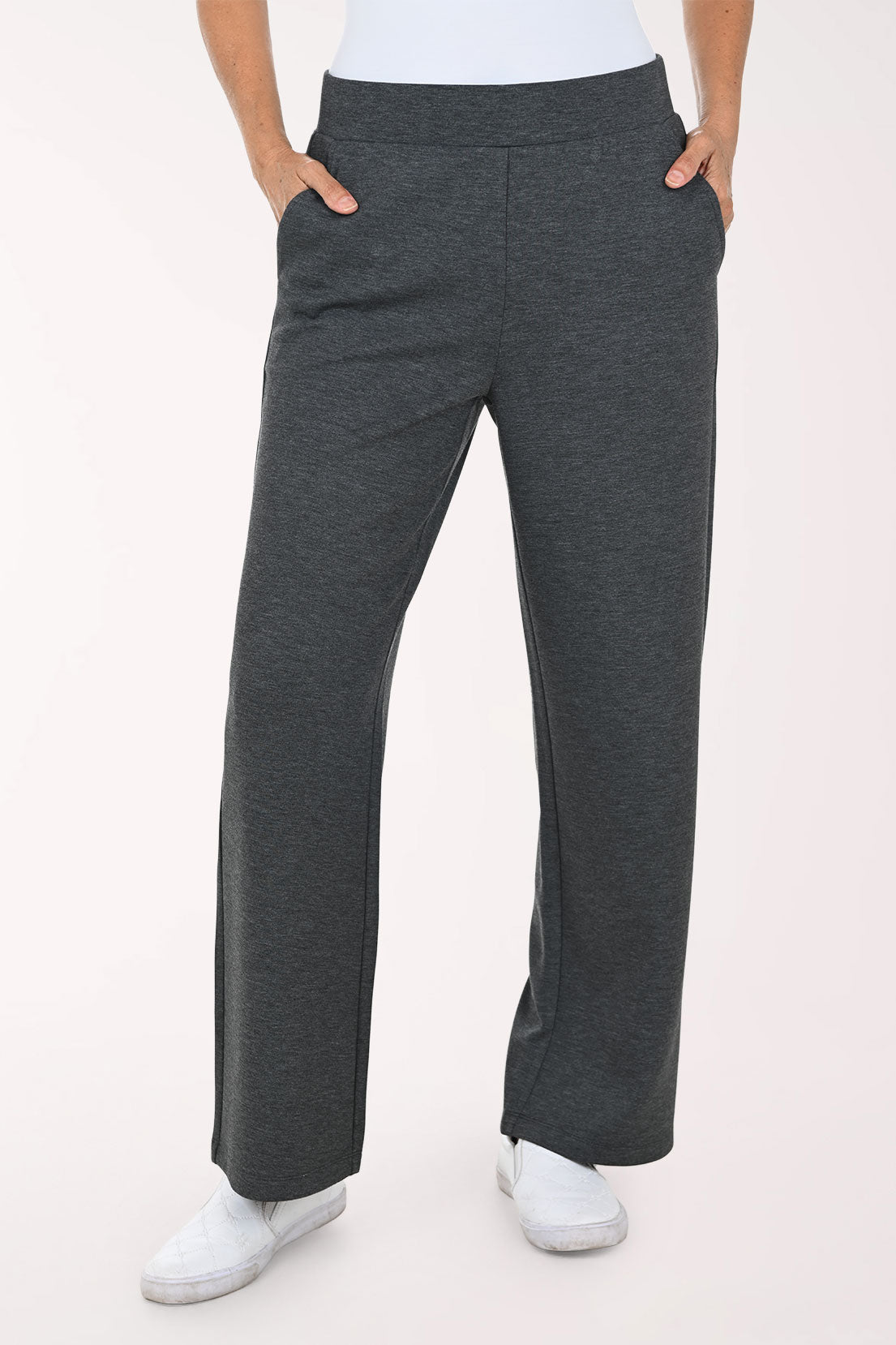 A person wearing dark heather gray wide-leg pants with side pockets, paired with a white top and white sneakers, shown against a plain light background.