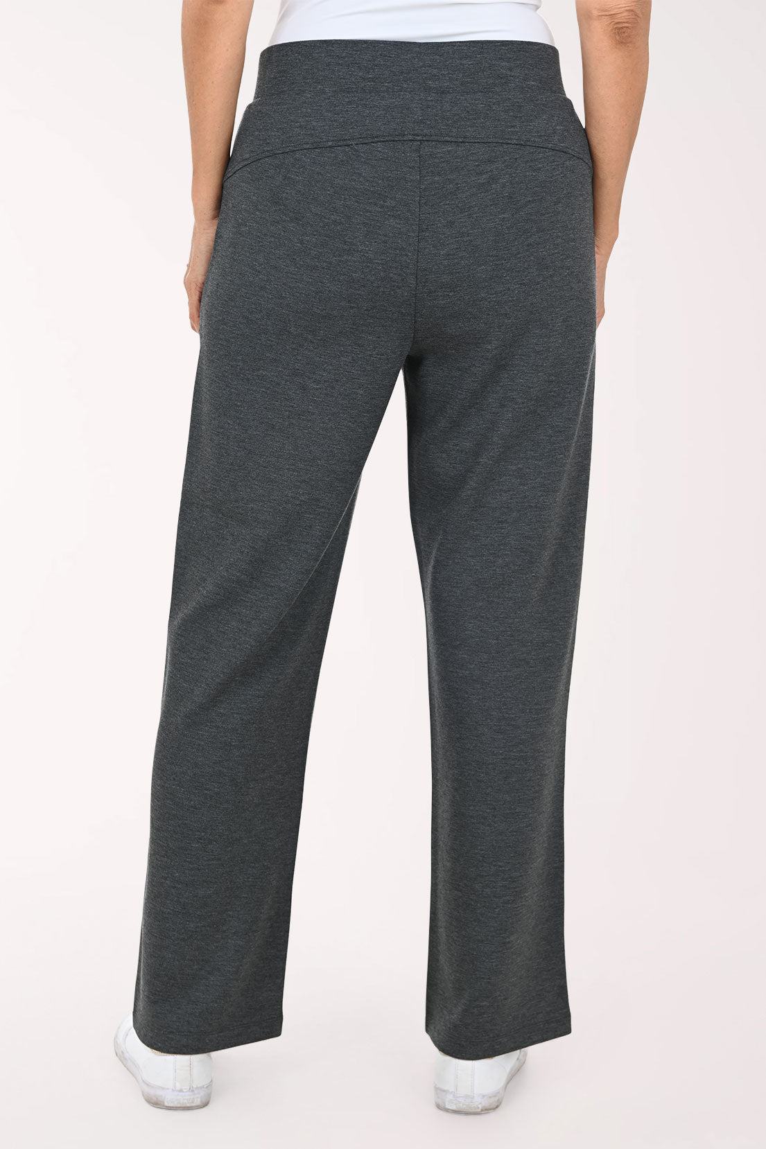 A person wearing dark heather gray wide-leg pants with side pockets, paired with a white top and white sneakers, shown against a plain light background.