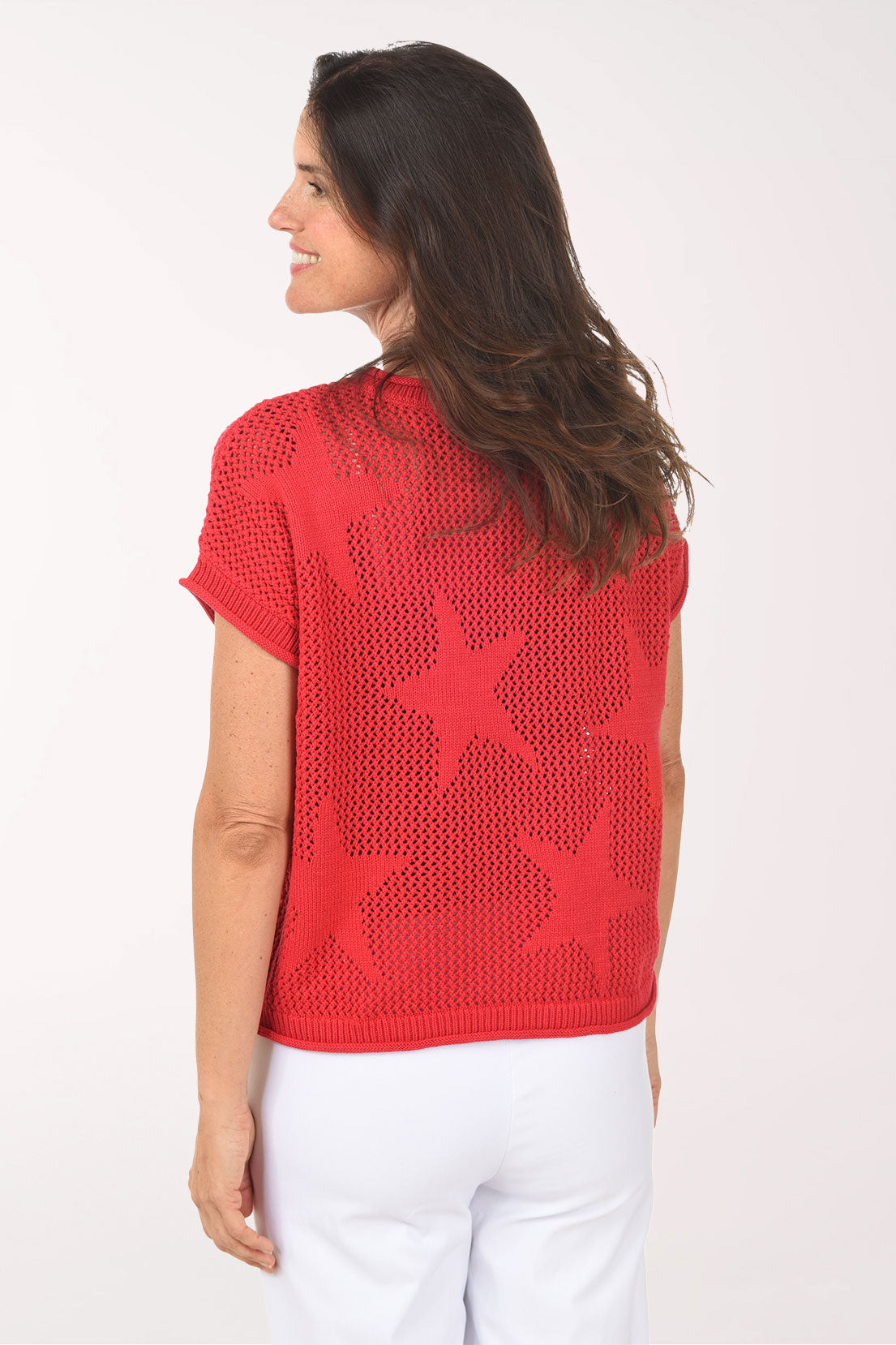 Woman wearing a red star-patterned sweater on a white background