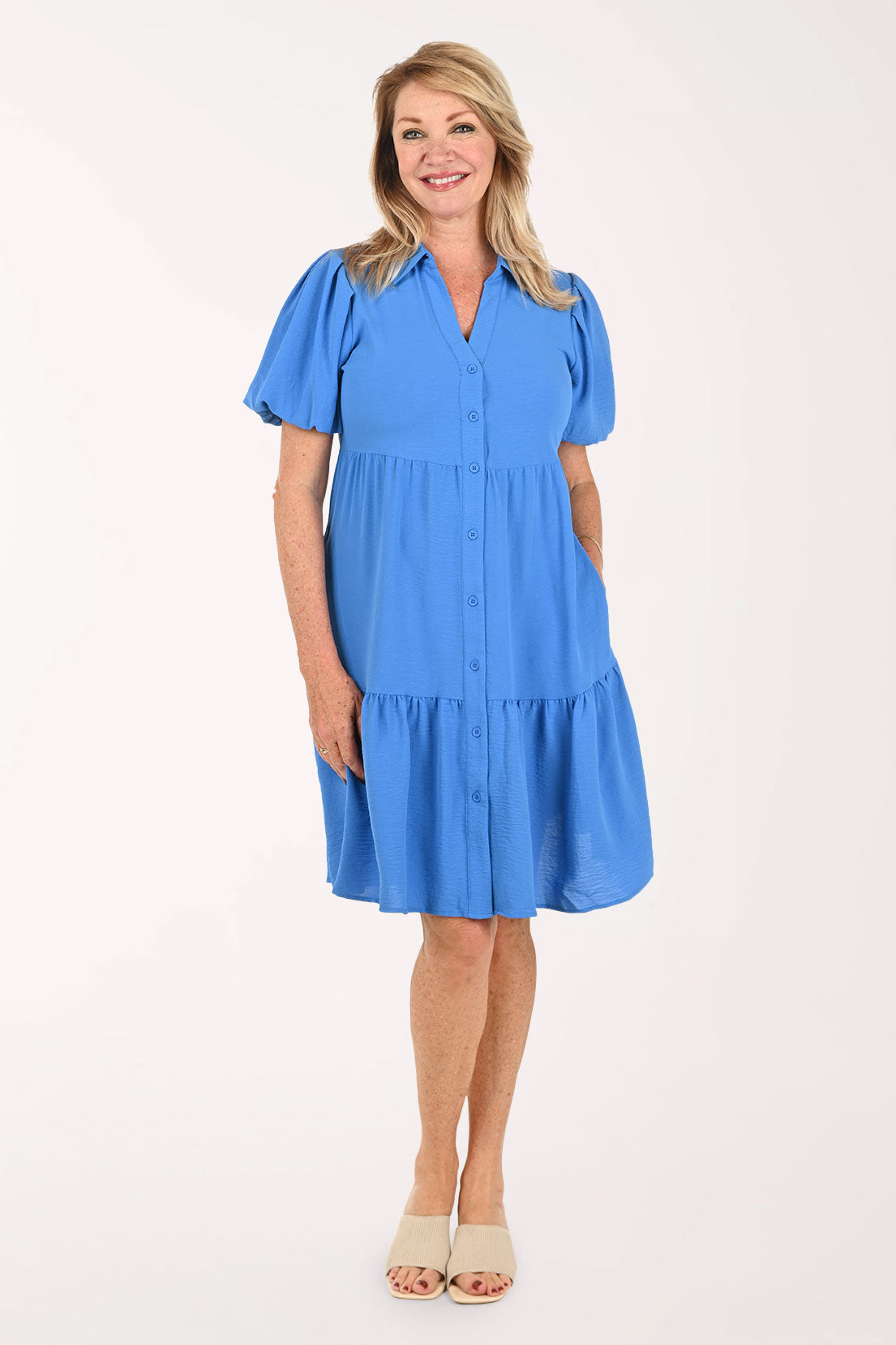 Woman wearing a blue tiered dress with short puff sleeves