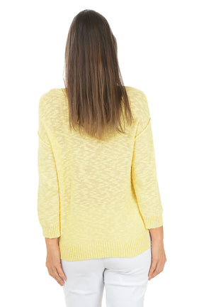 Woman wearing a yellow sweater and white pants on a white background. Back shot.