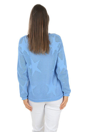 Woman wearing a light blue sweater and white pants on a white background. Back shot.