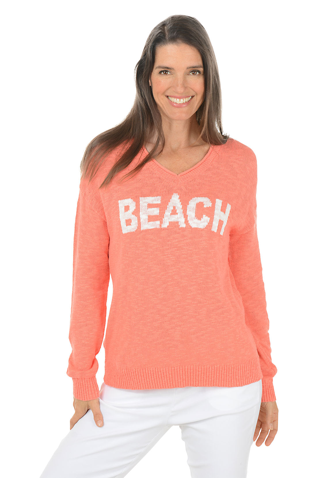Woman wearing a coral sweater with 'BEACH' text on a white background.
