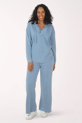 Woman wearing a light blue sweater and sweatpants set on a white background