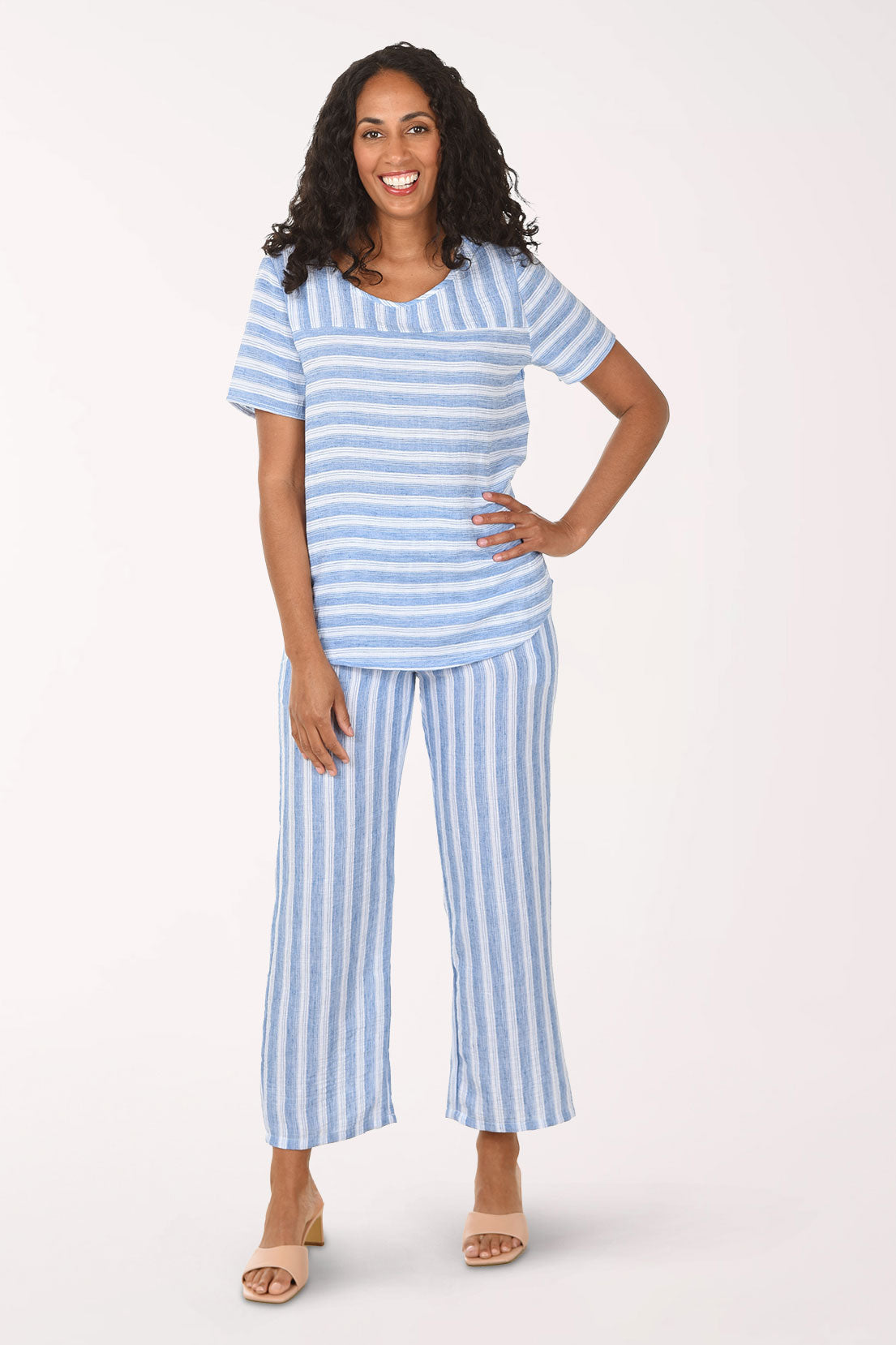 Woman wearing a blue and white striped pajama set on a white background