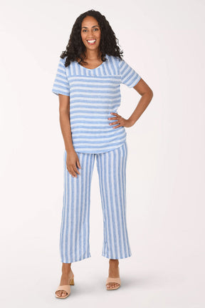 Woman wearing a blue and white striped pajama set on a white background