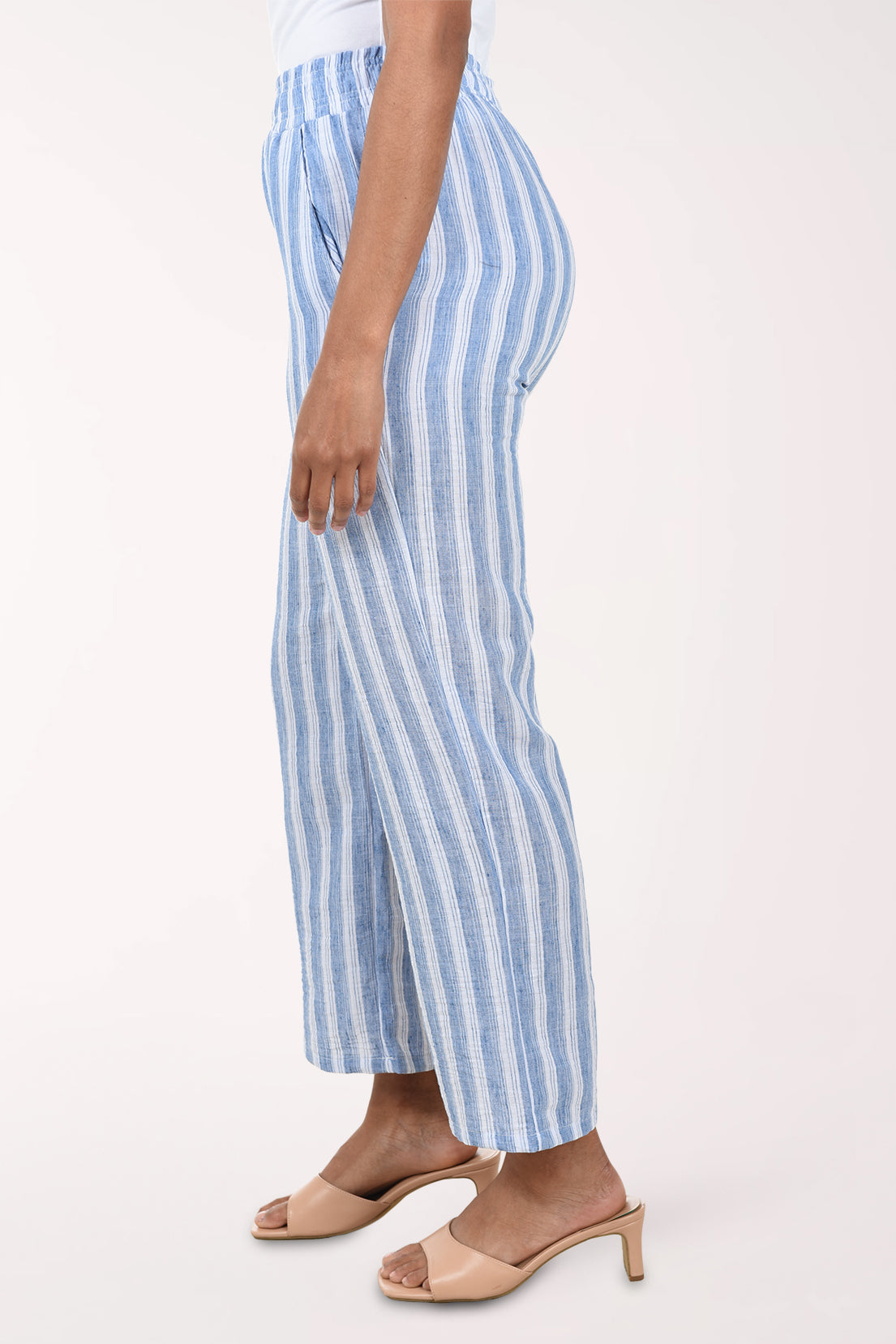 Blue and white striped pants worn by a person on a white background