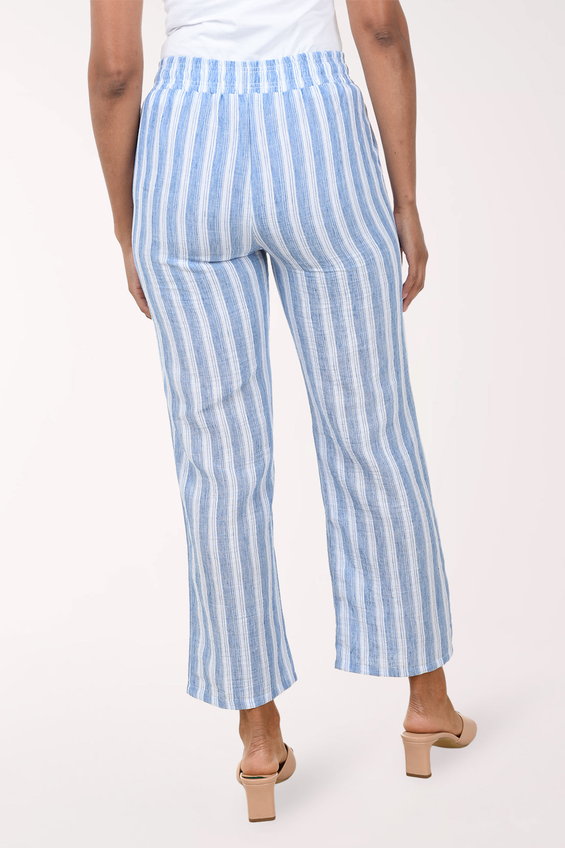 Blue and white striped pants worn by a person on a white background