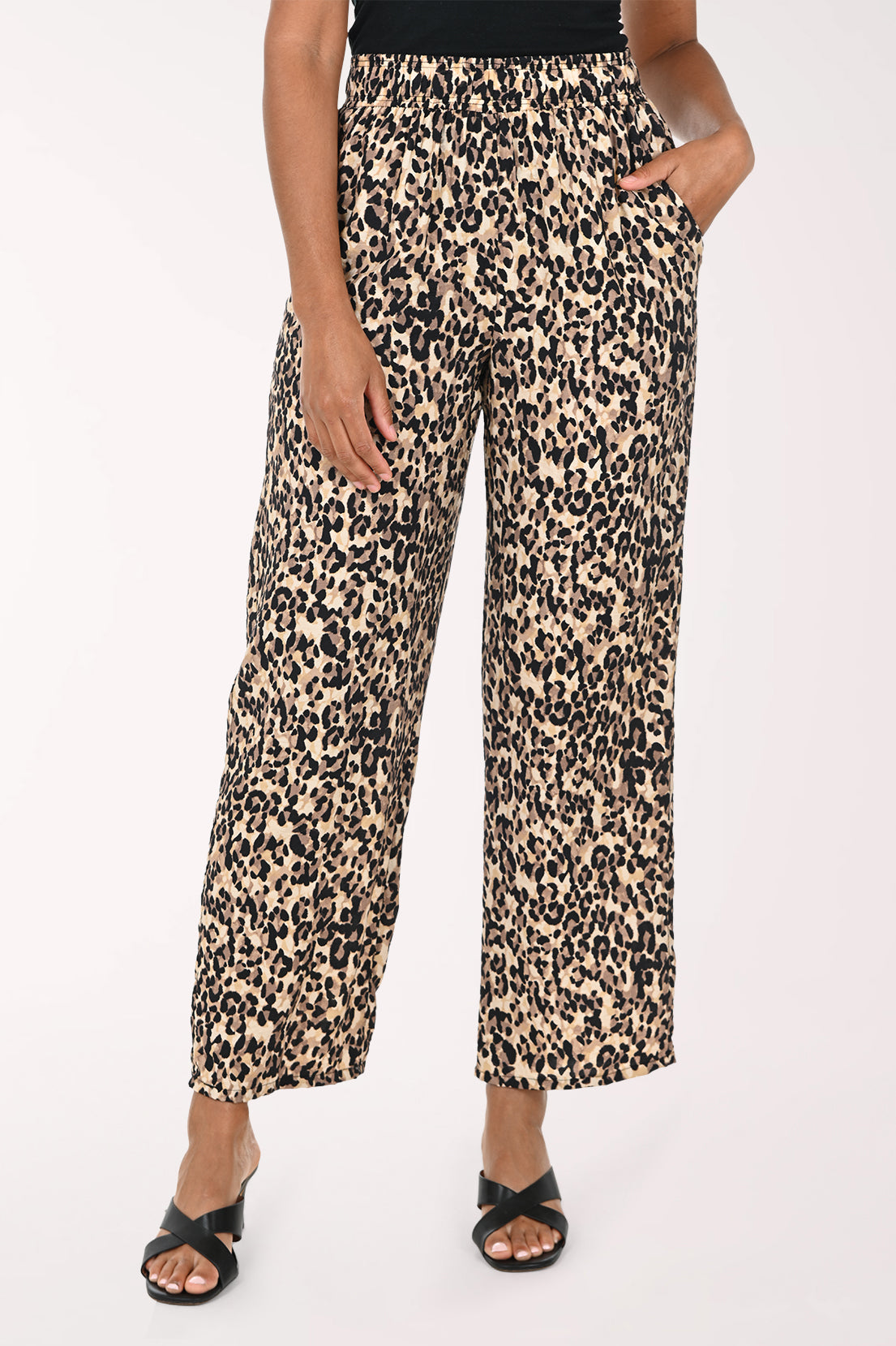Leopard print pants worn by a person on a white background