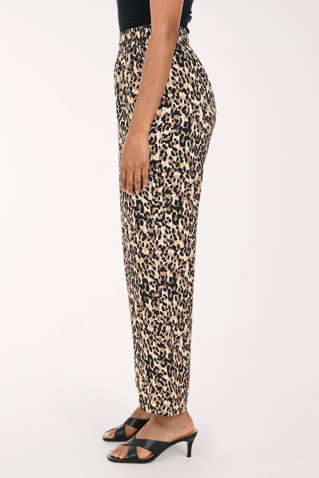 Leopard print pants worn by a person on a white background