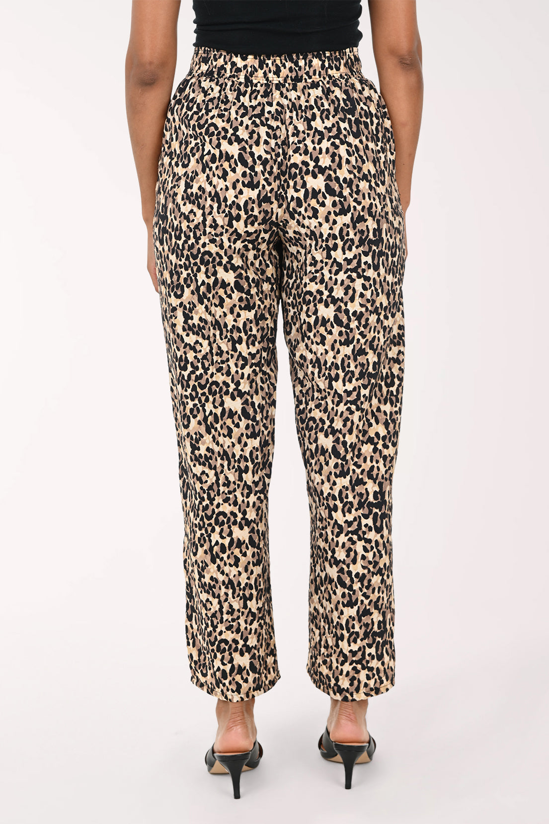 Leopard print pants worn by a person on a white background