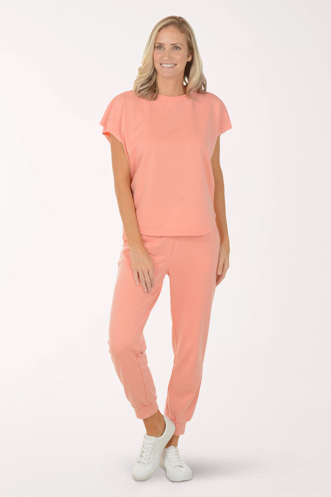 Woman wearing a coral outfit with a plain background