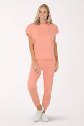 Woman wearing a coral outfit with a plain background