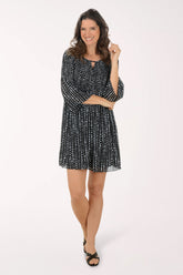 Woman wearing a black and white patterned dress on a white background