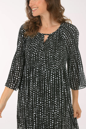 Woman wearing a black and white patterned dress on a white background