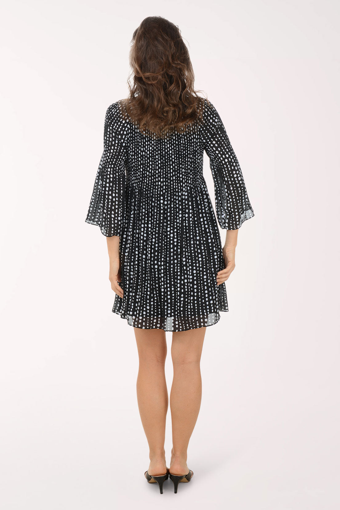 Woman wearing a black and white patterned dress on a white background