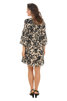 Woman wearing a floral dress on a white background. Back shot.