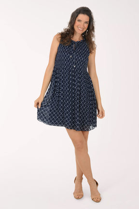 Woman wearing a navy blue patterned dress on a white background