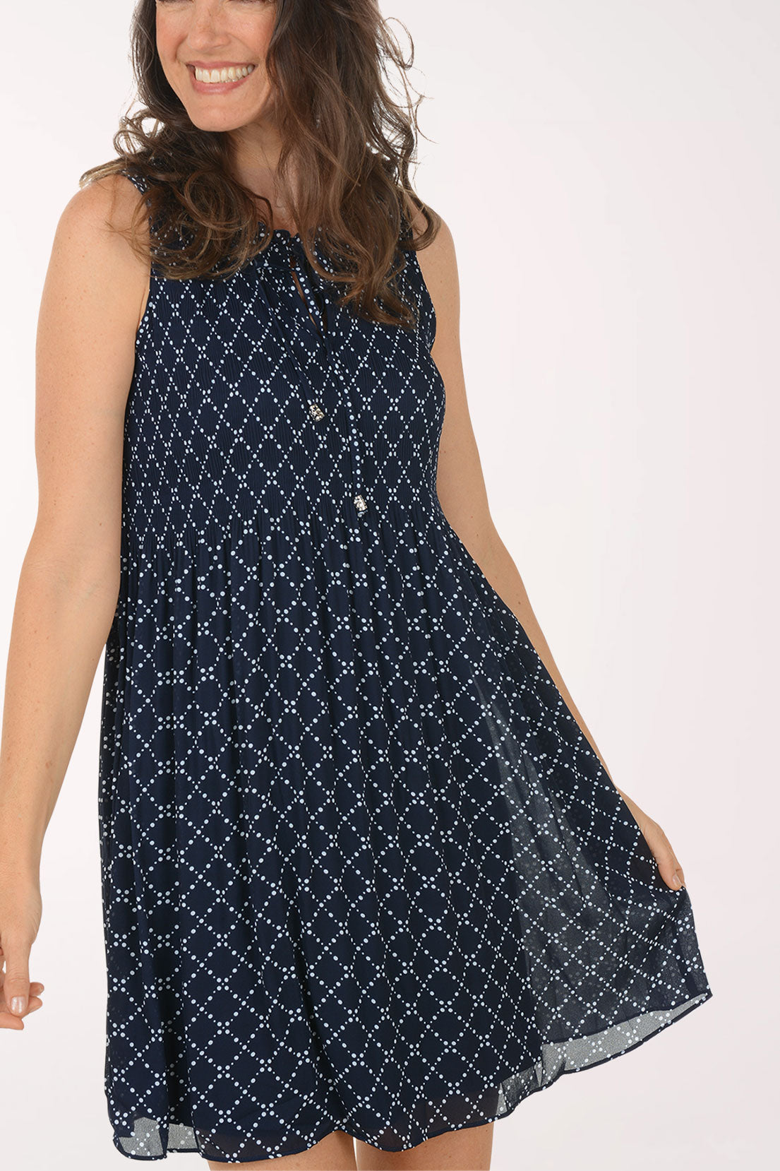 Woman wearing a navy blue patterned dress on a white background