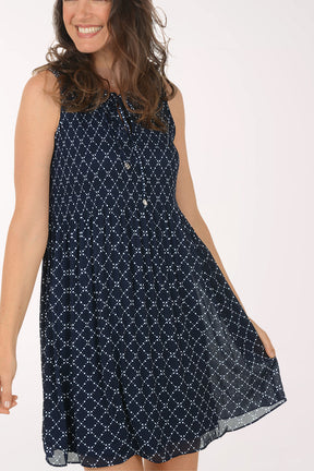 Woman wearing a navy blue patterned dress on a white background