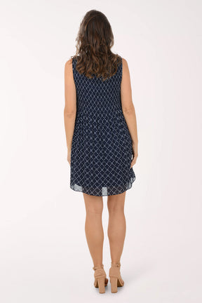 Woman wearing a navy blue patterned dress on a white background