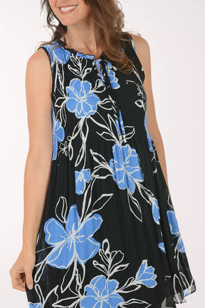Woman wearing a black dress with blue floral pattern on a white background
