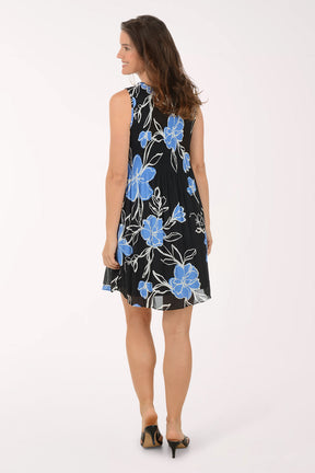 Woman wearing a black dress with blue floral pattern on a white background