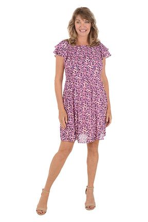 Woman wearing a multi pink animal patterned dress with cap flutter sleeves.