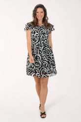 Woman wearing a black and white patterned dress on a white background