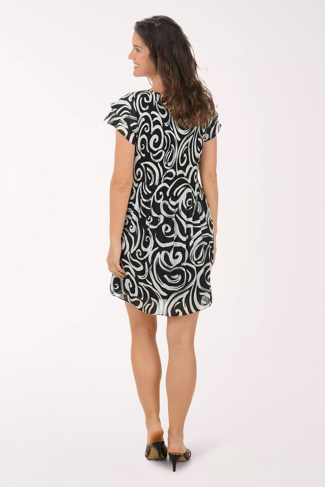 Woman wearing a black and white patterned dress on a white background