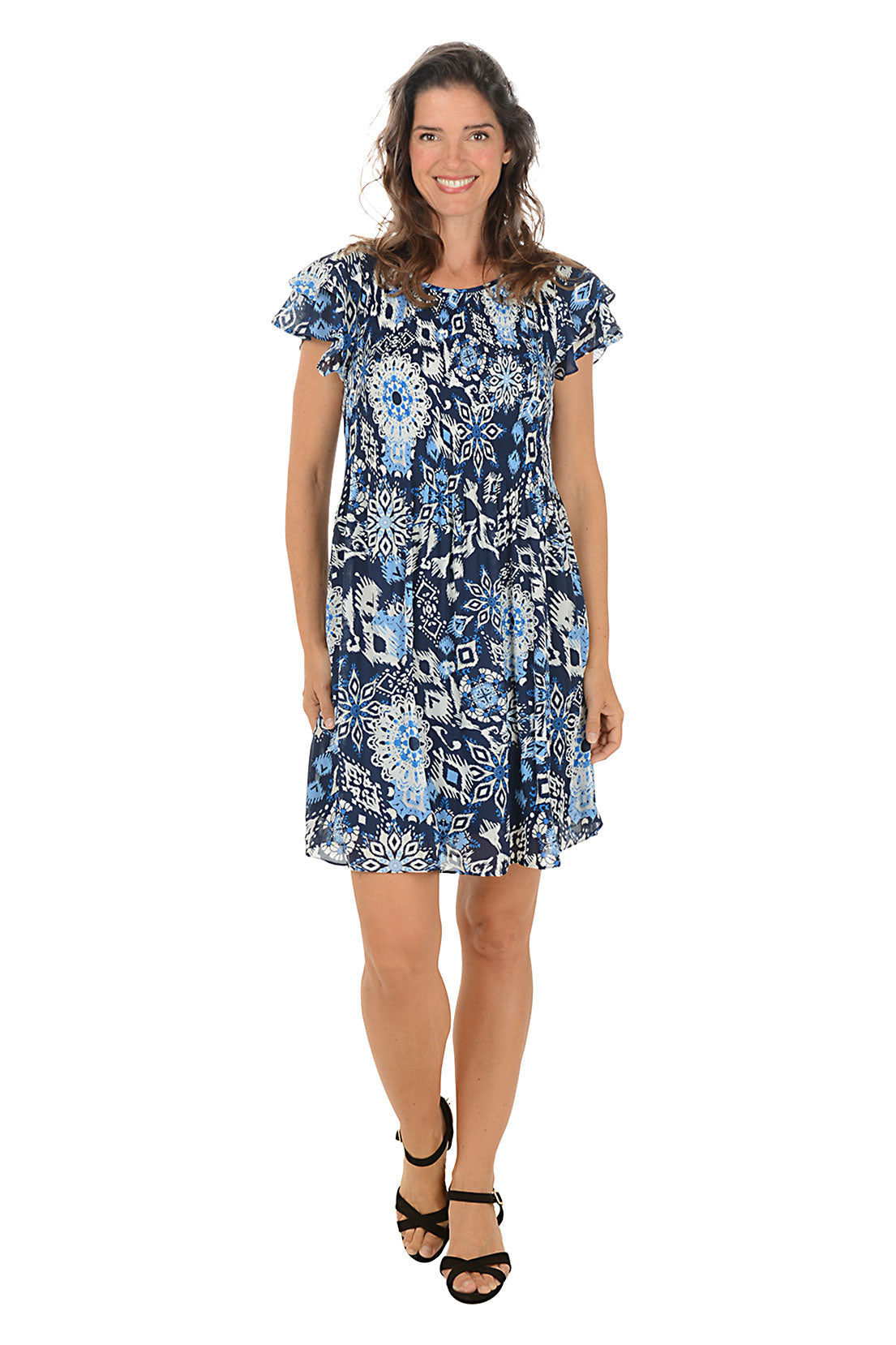 Woman wearing a ruffled short sleeve blue floral dress on a white background.