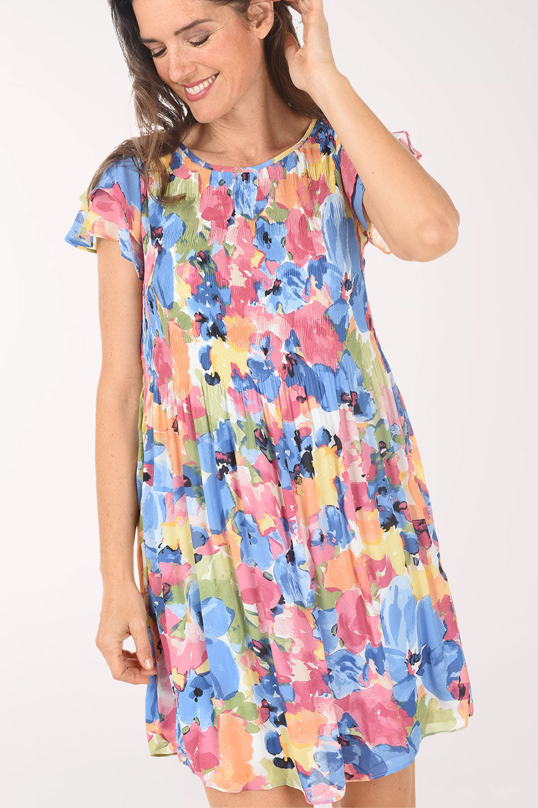 Woman wearing a colorful floral dress on a white background