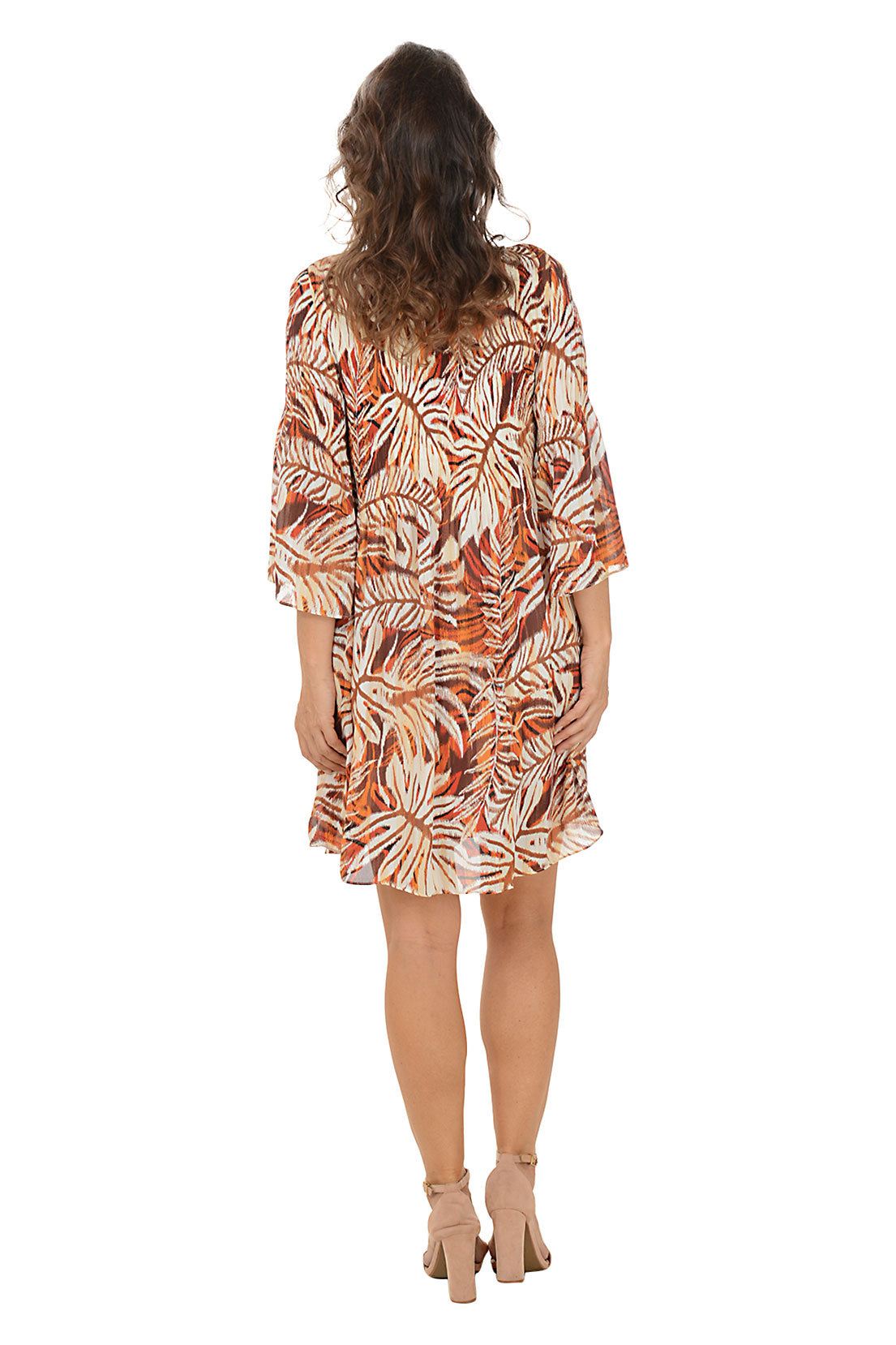 Woman wearing a patterned dress on a white background. Back shot.