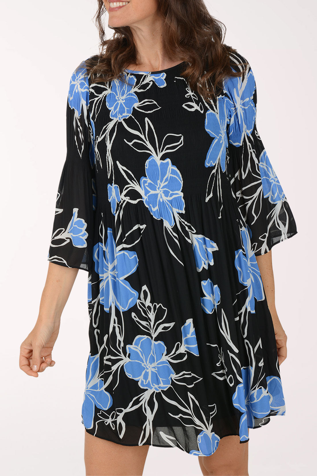 Woman wearing a black dress with blue floral patterns on a white background