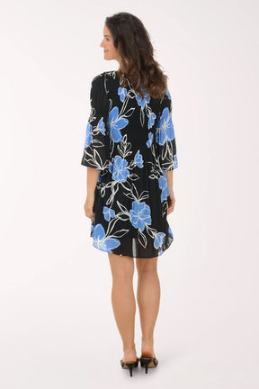 Woman wearing a black dress with blue floral patterns on a white background