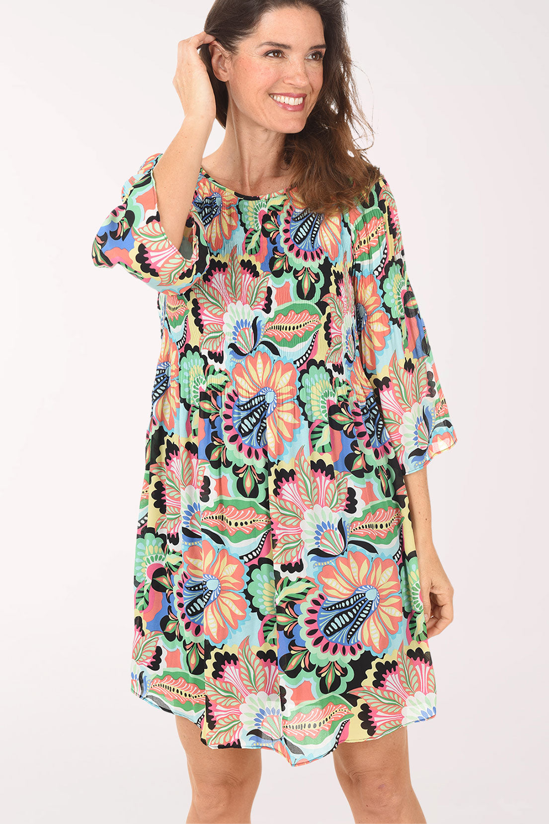 Woman wearing a colorful floral dress on a white background