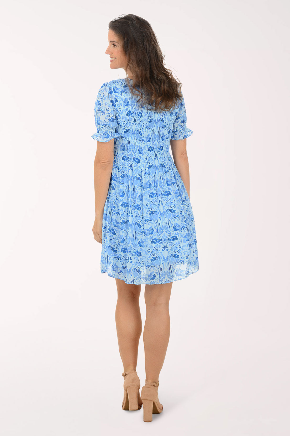 Woman wearing a blue floral dress on a white background