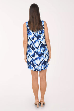 Woman wearing a blue and white patterned dress on a white background