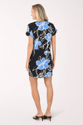 Woman wearing a black dress with blue floral patterns on a white background