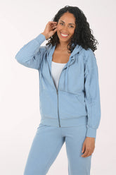 Woman wearing a light blue tracksuit on a white background