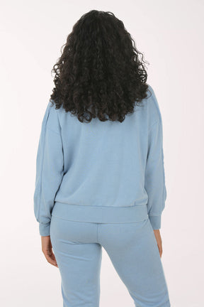 Woman wearing a light blue tracksuit on a white background