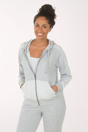 Woman wearing a gray zip-up hoodie and pants on a white background