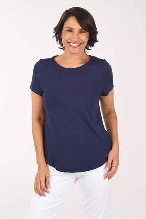Woman wearing a navy blue t-shirt and white pants on a white background