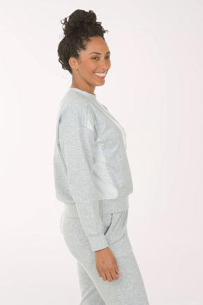 Woman wearing a gray sweatshirt and pants on a white background
