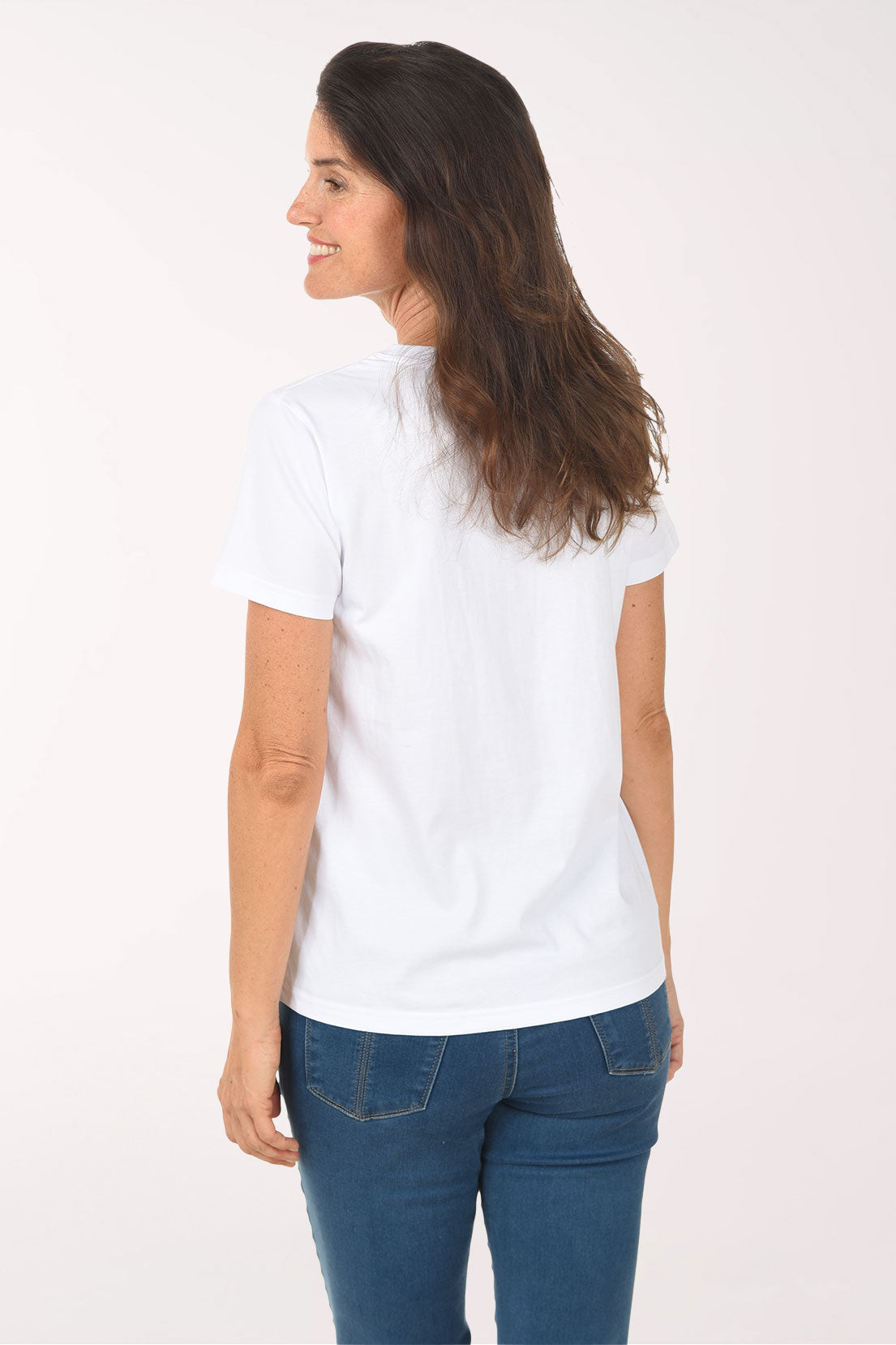 Woman wearing a white t-shirt with dog illustrations on a plain background