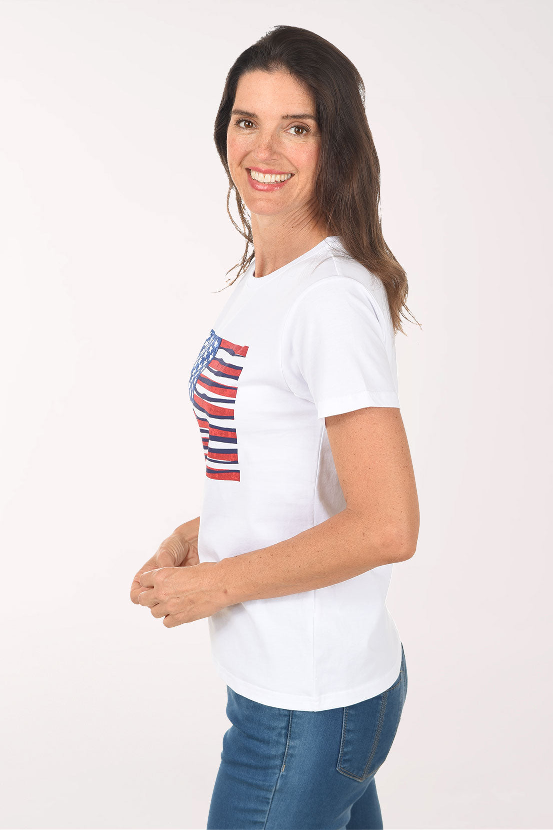 Woman wearing a white t-shirt with an American flag design on a plain background