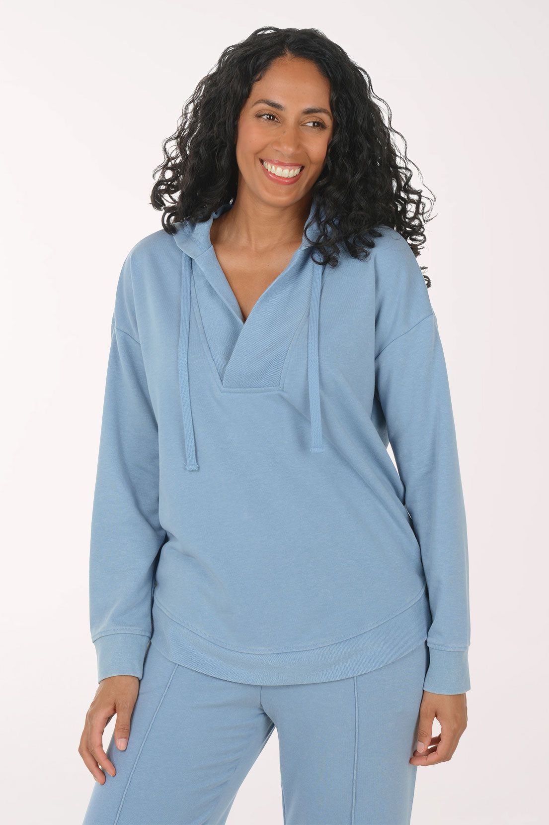 Woman wearing a light blue hoodie and pants on a white background