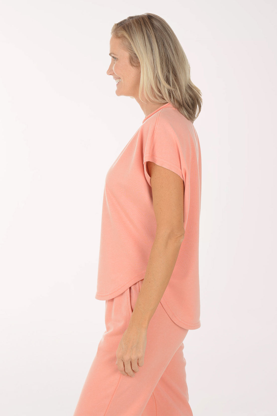 Woman wearing a peach-colored outfit on a white background